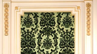 A photo of the artistic textiles on the walls of Asahi no Ma. Dark green velvet is flocked on pale grass-green silk damask to make the pattern flowers and leaves stand out.