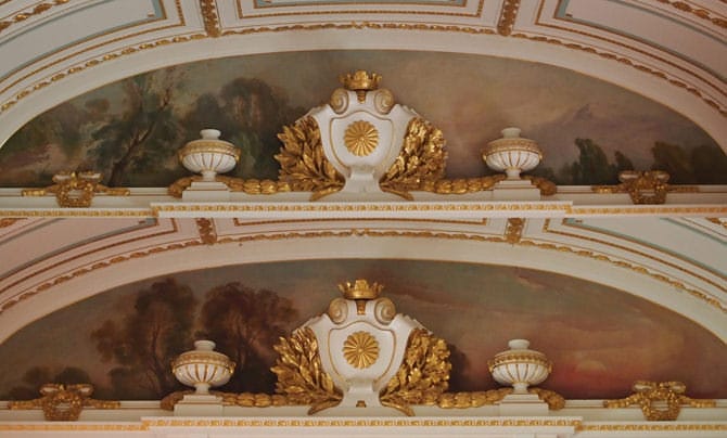 Une photo des peintures sur l’arche juste au-dessus de l’escalier central. Une photo de la peinture que l’on voit en montant au premier étage, et de celle que l’on voit en redescendant ont été combinées sur cette image. Derrière l’emblème du chrysanthème impérial, un fond représentant l’aube a été peint sur le côté menant au premier étage, tandis que sur celui menant au rez-de-chaussée, c’est un tableau du crépuscule.