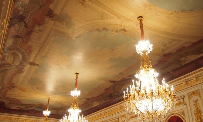 En levant les yeux au plafond, on aperçoit le ciel qui s’étend au-dessus, comme si l’on regardait vers le haut depuis une cour du bâtiment. 