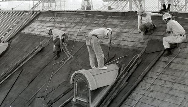 Una imagen de los trabajos de reforma que comenzaron en la Casa de Invitados del Estado, Palacio de Akasaka, en 1910. Obreros subidos en el tejado, donde están cambiando las tejas.