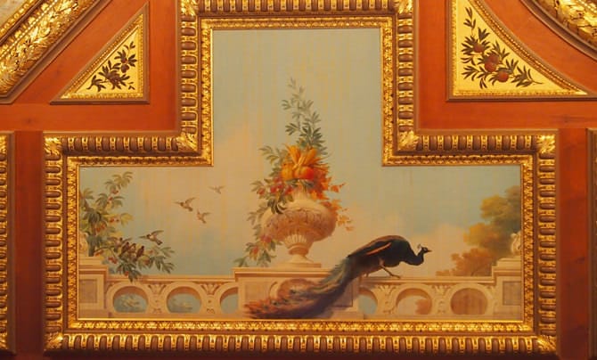 A photo of a ceiling painting in Kacho no Ma. A peacock and flowers are painted in oils on the coffered ceiling.