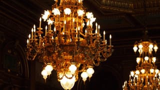 A photo of the chandeliers in Kacho no Ma. Shimmering in gold, they appear very stately.