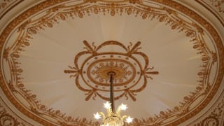 Une photo du plafond de la salle Sairan no Ma. On voit des reliefs en stuc le long d’une arche elliptique, avec un motif composé de lignes rayonnant depuis son centre, créant un dessin évoquant une tente.