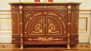 A photo of furniture in Sairan no Ma. Golden decorations have been applied to the mahogany.