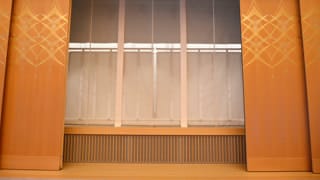 Une photo de la scène avec les portes ouvertes. Les portes sont décorées de « kirikane » en feuilles d'or et, sur la scène, on a abaissé un rideau dont on dit qu'il est si fin que la moindre brise en agiterait les fils. On peut entrapercevoir un paravent à travers le rideau.