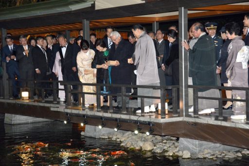 H.E.Dr. Tony Tan Keng Yam, the President of the Republic of Singapore and Mrs. Mary TAN Chee Bee Kiang are feeding Koi carp from the Rokyo covered bridge.
