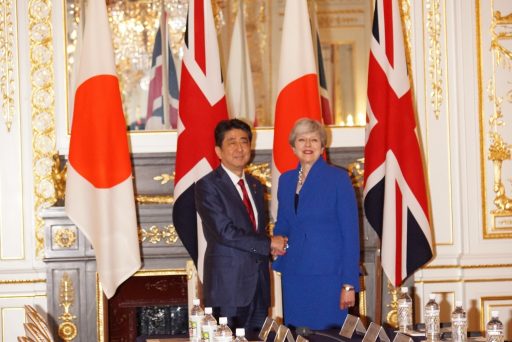 彩鸞の間において、首脳会談の開始前に国旗の前で握手をする英国メイ首相と安倍総理の写真