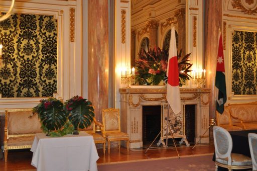 首脳会談の会場となった朝日の間の写真。部屋にはヨルダンの国旗をイメージした装花が飾られ、中央にはヨルダン王国と日本の国旗が並んでいる。