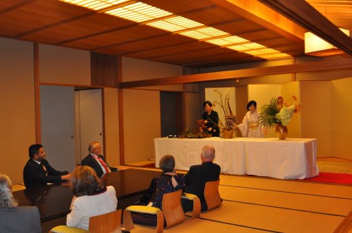 和風別館の主和室において、アジア太平洋最高裁判所長官たちが華道の鑑賞をしている様子。長官たちの前で先生が生花をしています。