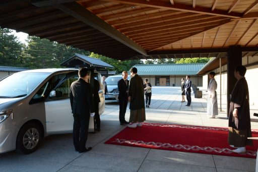 President is getting out of the car and greeted by the Vice Director of the State Guest House at the Main Entrance