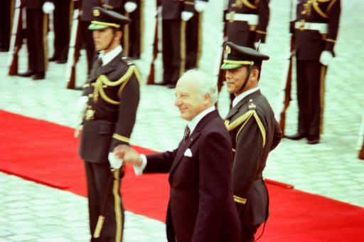 President Scheel walks on the red carpet waving his hand to welcoming members at the welcome ceremony in the front garden